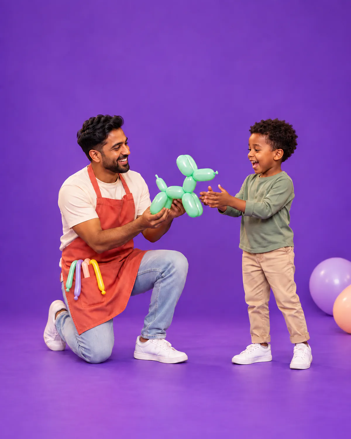 A balloon artist handing a green balloon dog to a delighted boy