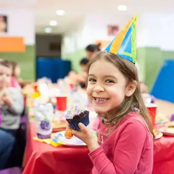 A lively kids birthday party scene with decorations and children playing