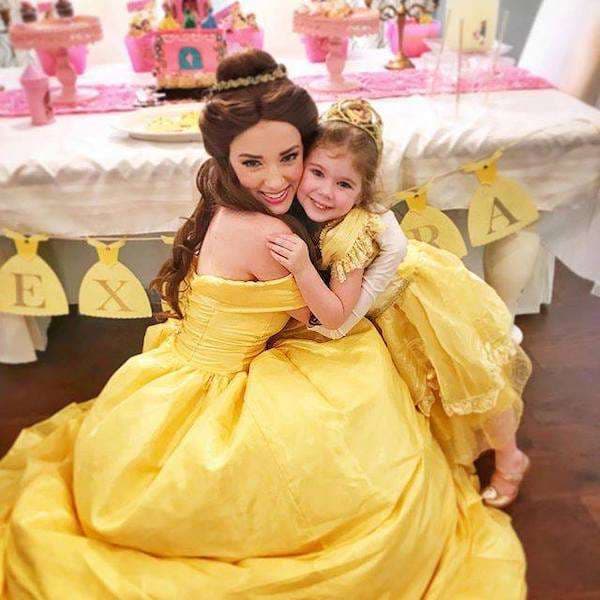A princess character hugging a delighted child at a princess party