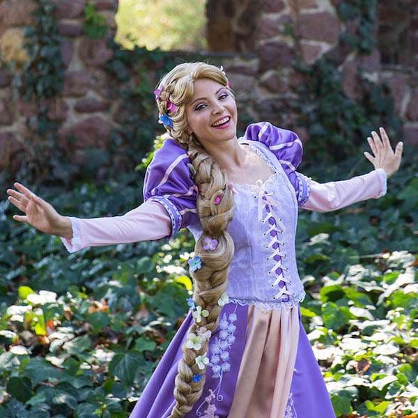 A costumed princess character entertaining a child at a birthday party